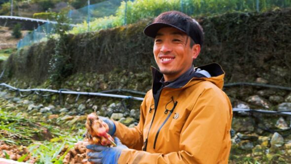 豊作に顔をほころばせる慎一さん